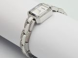a close up of a watch on a napkin on a white surface