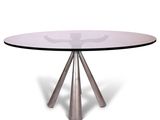 une table ronde en verre avec trois pieds en métal et un plateau en verre