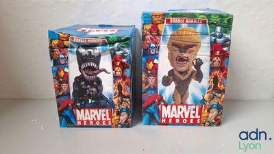 deux boîtes de figurines de héros Marvel posées l'une à côté de l'autre