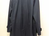 the back of a black coat hanging on a wall