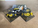 three yellow race cars sitting on top of each other in a display case