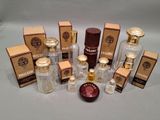 plusieurs flacons de parfum posés sur une table, à côté de boîtes de parfum