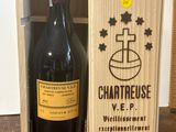 une bouteille de vin dans un coffret en bois, posée sur une table en bois