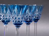 four blue wine glasses sitting on top of a table