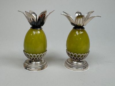 two silver and green vases with flowers on them
