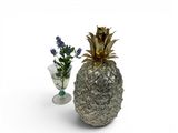 a glass vase with a pineapple on it next to a vase with a flower in it