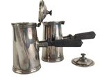 a silver coffee pot with a gun on it