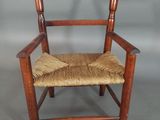 an old wooden chair with a woven seat on a gray background
