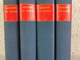 quatre livres bleus posés les uns à côté des autres sur une table