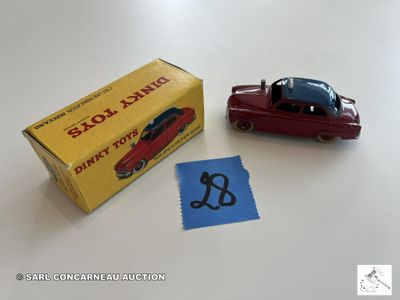 une petite voiture miniature posée à côté d'une boîte d'autocollants