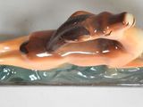 a figurine of a woman laying down on the ground