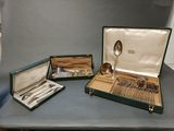 three different types of silverware in a case on a table