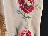 a close up of a white scarf with red flowers on it
