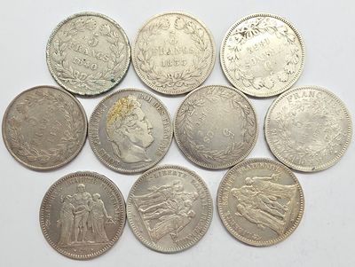 six types différents de pièces d'argent sur une surface blanche