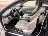 the interior of a car with the door open and the driver ' s seat down