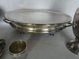 a silver plate and silver cups on a table