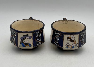 une paire de tasses bleues et blanches ornées d'une illustration représentant un homme et une femme