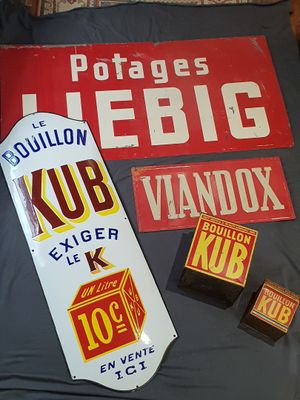 a lot of old signs on a bed in a room