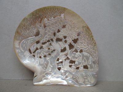 un coquillage blanc sur lequel est représenté un dragon