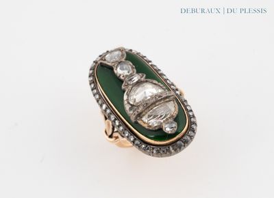 a close up of a ring on a white surface with diamonds