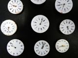 neuf horloges posées sur une table noire, sur fond noir