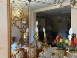 un miroir posé sur une table sur laquelle se trouve un vase de fleurs