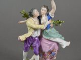 two figurines of a man and a woman on a rock