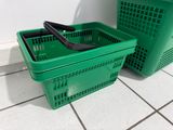 two green baskets sitting on the floor next to each other