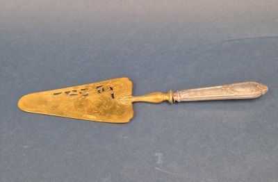 une spatule ancienne plaquée or sur un fond bleu