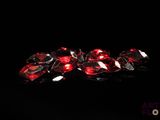 a close up of a bunch of red crystals on a black surface