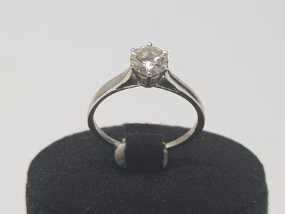 an image of a diamond ring sitting on a black ring holder