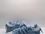 Les baskets adidas sont bleues et blanches, avec une semelle bleu clair.