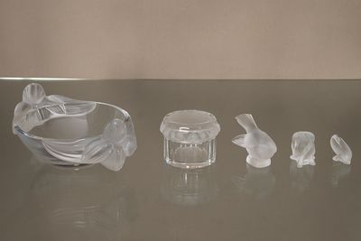 de nombreux animaux en verre posés sur une table, à côté d'un bol