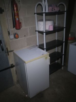 a small white refrigerator in the corner of a room