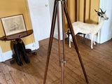 un télescope posé sur un trépied dans une pièce jaune