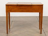 a small wooden table with a drawer on top of it