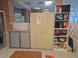 a room with a desk, cabinets, and a chair in it