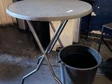a small table with a bucket on it in a room
