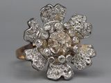 an image of a diamond flower ring on a gray background