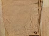 beige pants on a wooden floor with a tag on it