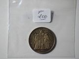a small coin with a picture of a man and a woman on it