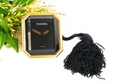 a black and gold clock with a tassel around it