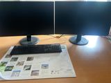 two monitors and a keyboard sitting on a desk
