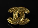 a chanel gold plated brooch with a circular design