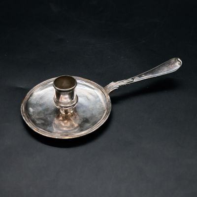 a silver plate with a spoon on it on a black surface