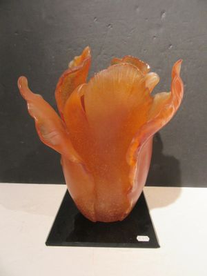 a glass vase with a flower inside of it on a stand
