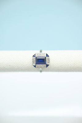 a blue sapphire and diamond ring on a white napkin