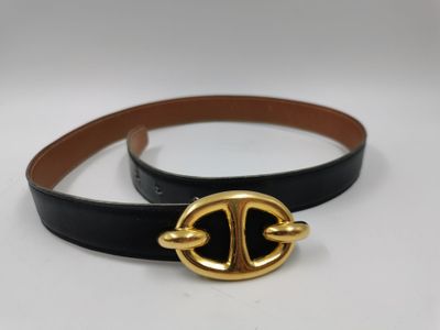 Gros plan sur une ceinture noire avec une boucle dorée