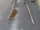 two shovels laying on the ground next to each other