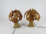 pair of ceramic sculptures of a dragon and a flower on a stand